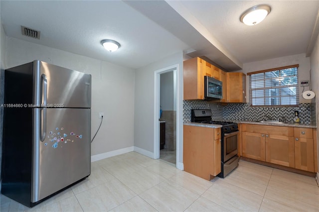 kitchen featuring sink, light tile patterned floors, stainless steel appliances, a textured ceiling, and decorative backsplash