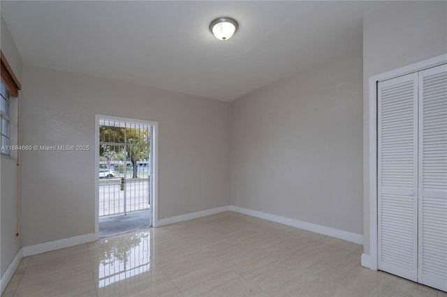 unfurnished bedroom featuring access to outside, light tile patterned floors, and a closet