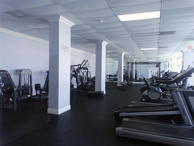 gym featuring a drop ceiling and ornamental molding