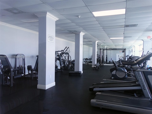 exercise room with crown molding, baseboards, decorative columns, and a paneled ceiling