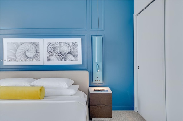 bedroom featuring a closet and light colored carpet