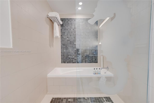 bathroom featuring tile patterned flooring, tile walls, and separate shower and tub