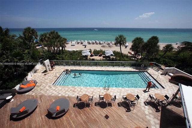 view of pool with a patio and a water view