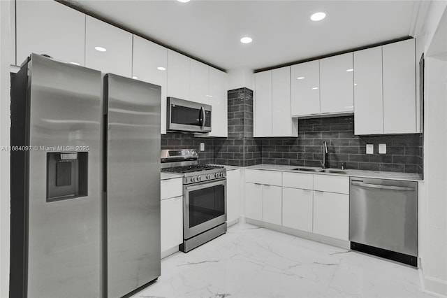 kitchen with sink, decorative backsplash, stainless steel appliances, and white cabinets