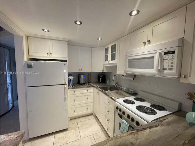 kitchen with decorative backsplash, white cabinets, sink, and white appliances