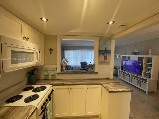 kitchen featuring tile patterned floors, backsplash, crown molding, white cabinetry, and white appliances