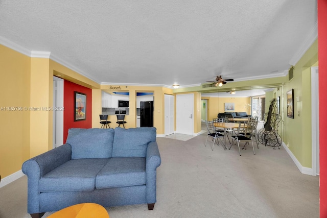 living room with ornamental molding, a textured ceiling, light colored carpet, and ceiling fan