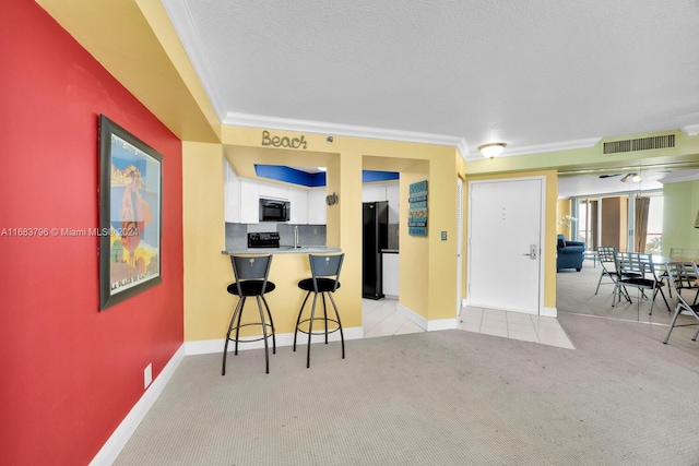 kitchen with black appliances, kitchen peninsula, a kitchen breakfast bar, white cabinets, and light colored carpet