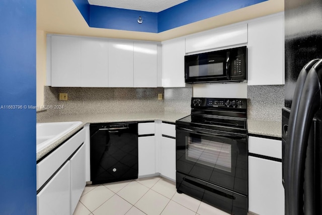 kitchen featuring decorative backsplash, white cabinets, and black appliances