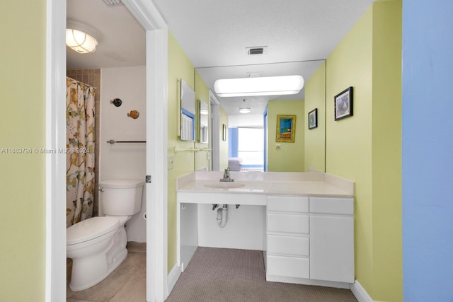 bathroom with tile patterned floors, sink, a textured ceiling, and toilet