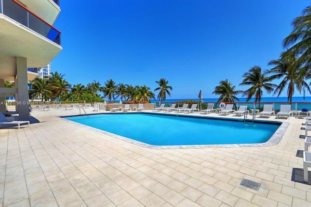 view of swimming pool featuring a patio area and a water view