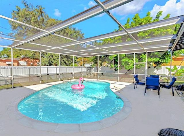 view of swimming pool with glass enclosure and a patio