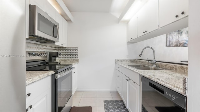 kitchen with decorative backsplash, light tile patterned floors, appliances with stainless steel finishes, white cabinetry, and sink