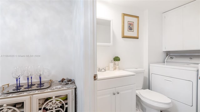 bathroom with vanity, toilet, and washer / clothes dryer