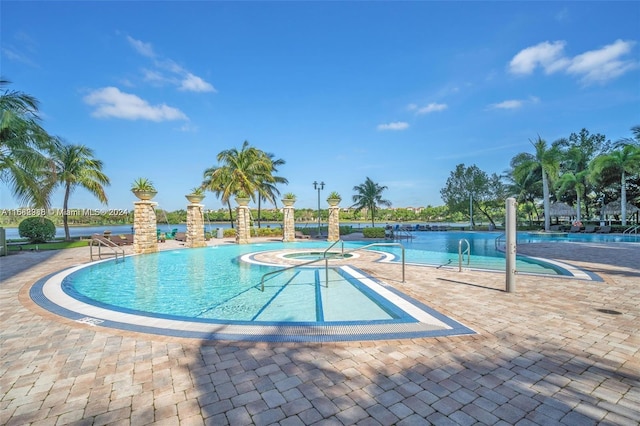 view of pool with a hot tub and a patio area