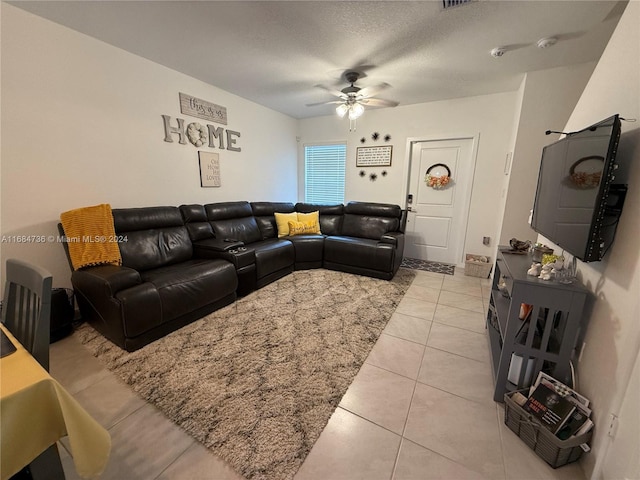 tiled living room featuring ceiling fan and a textured ceiling