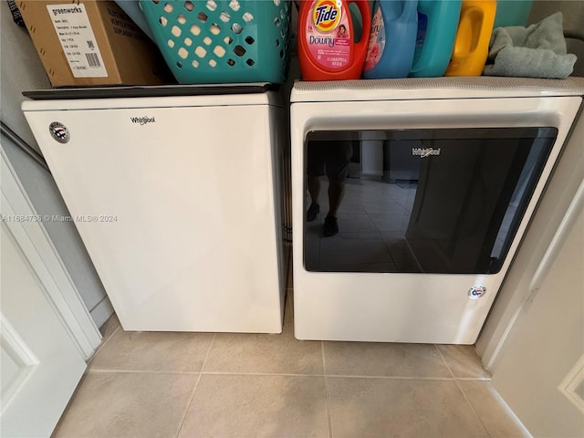 laundry room featuring light tile patterned flooring and washing machine and clothes dryer