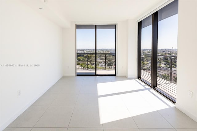 tiled spare room with a wall of windows