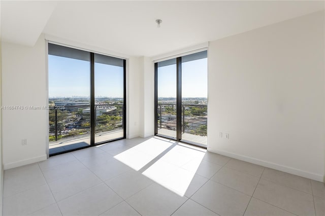 unfurnished room with light tile patterned floors and expansive windows