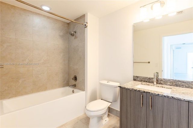 full bathroom with tile patterned floors, vanity, tiled shower / bath combo, and toilet