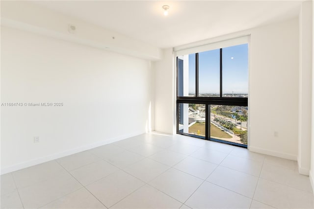 tiled empty room featuring floor to ceiling windows