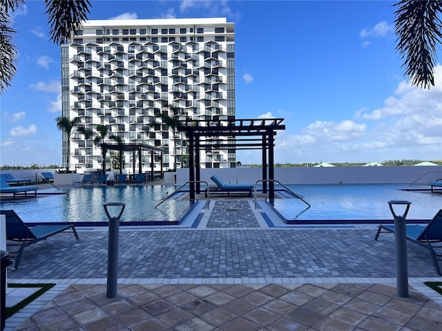 view of swimming pool with a water view and a patio area