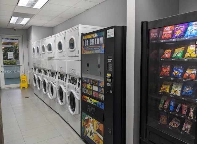 clothes washing area featuring light tile patterned floors, stacked washer and clothes dryer, and washer and dryer