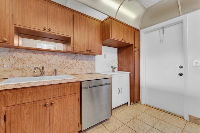 kitchen with light tile patterned floors, tasteful backsplash, sink, and stainless steel dishwasher