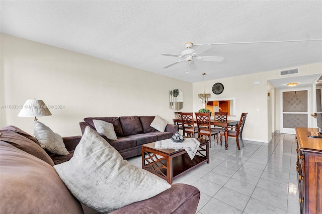 tiled living room featuring a textured ceiling and ceiling fan