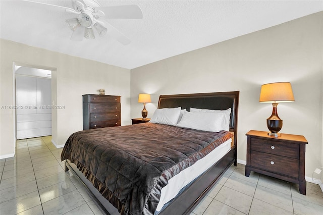 bedroom featuring ceiling fan, a textured ceiling, and light tile patterned flooring