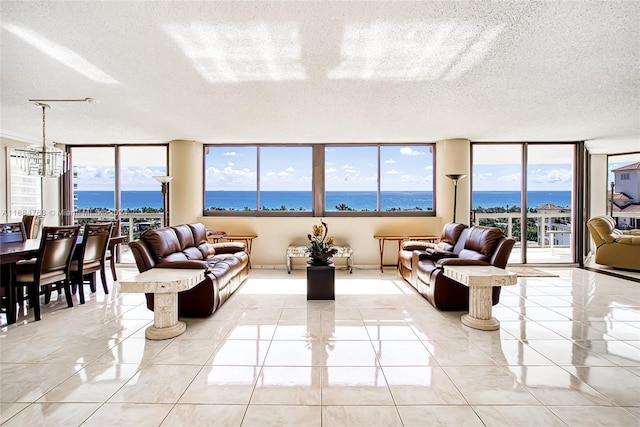 20185 E Country Club Dr Unit 1801, Aventura, FL 33180 - living room featuring a textured ceiling, a water view, and plenty of natural light