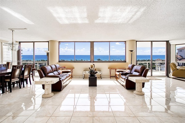 living room featuring a textured ceiling, a water view, and plenty of natural light