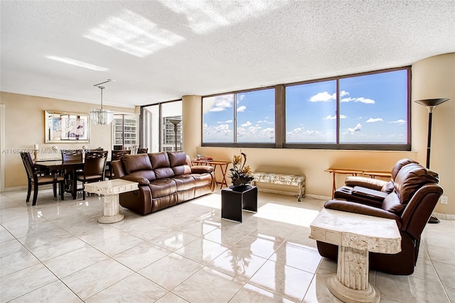 living room featuring a textured ceiling, light tile patterned floors, a chandelier, and a wall of windows