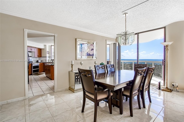 tiled dining space featuring a textured ceiling, floor to ceiling windows, a water view, crown molding, and an inviting chandelier