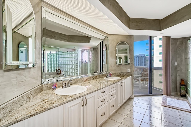 bathroom featuring vanity, a raised ceiling, tile patterned flooring, and a bath