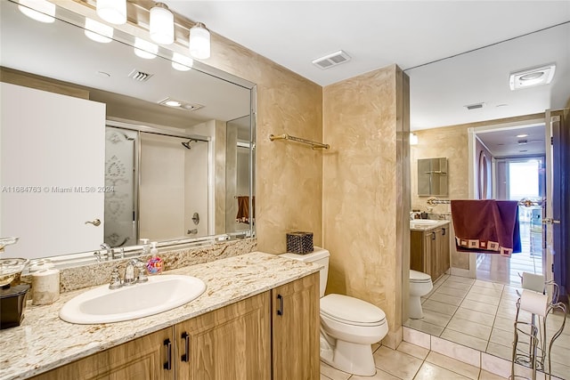 bathroom with vanity, tile patterned floors, toilet, and walk in shower