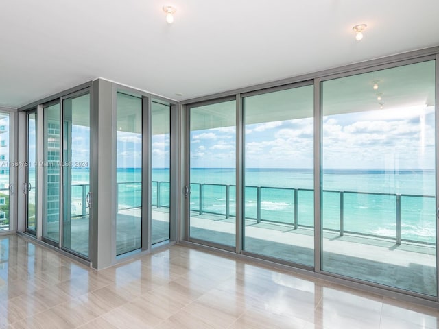 interior space featuring a water view and expansive windows