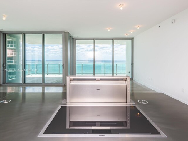 interior space with a water view and floor to ceiling windows