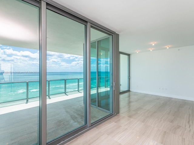 spare room featuring expansive windows and a water view