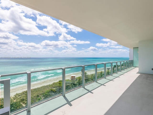 balcony with a water view and a beach view