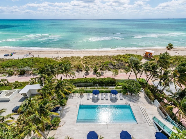 birds eye view of property featuring a water view and a beach view