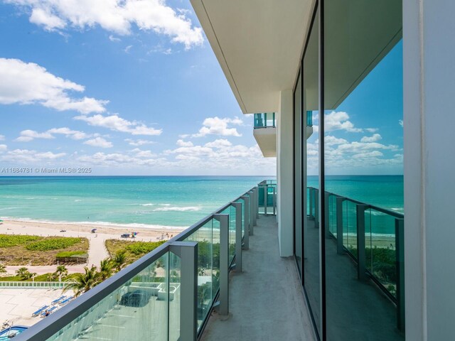 balcony featuring a water view and a view of the beach