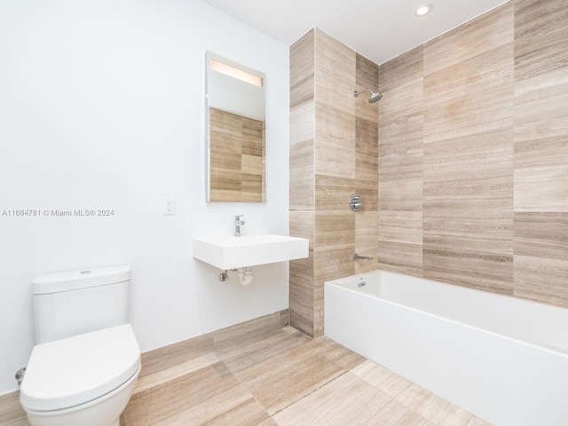 full bathroom with toilet, sink, and tiled shower / bath