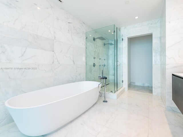 bathroom with vanity, tile walls, and separate shower and tub