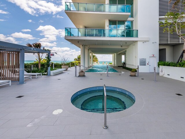 view of pool featuring a community hot tub and a patio