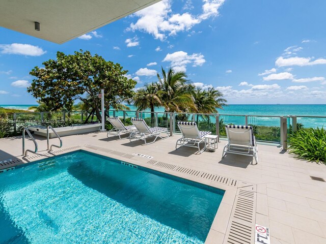 view of pool with a water view and a patio