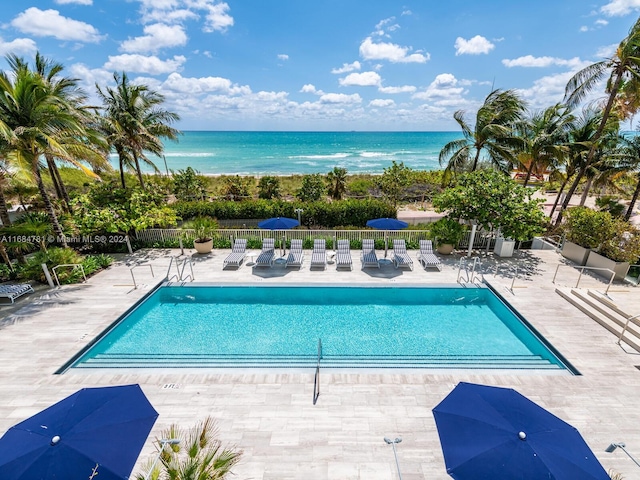 view of pool featuring a patio and a water view