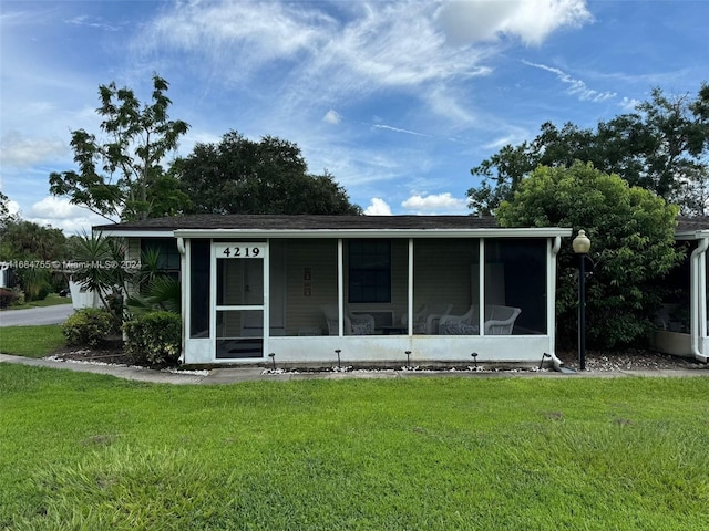 view of front of home with a front lawn and a sunroom