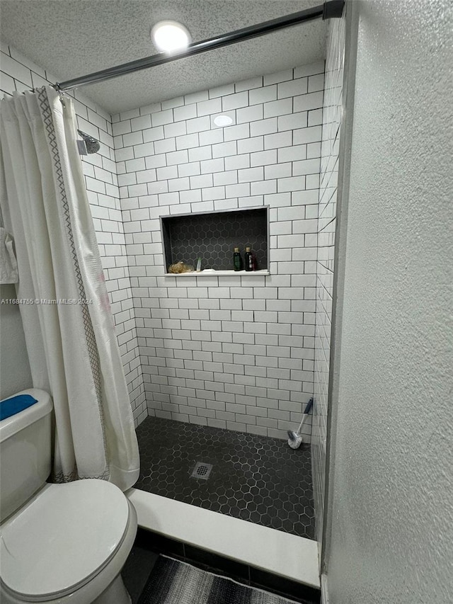 bathroom with curtained shower, a textured ceiling, and toilet