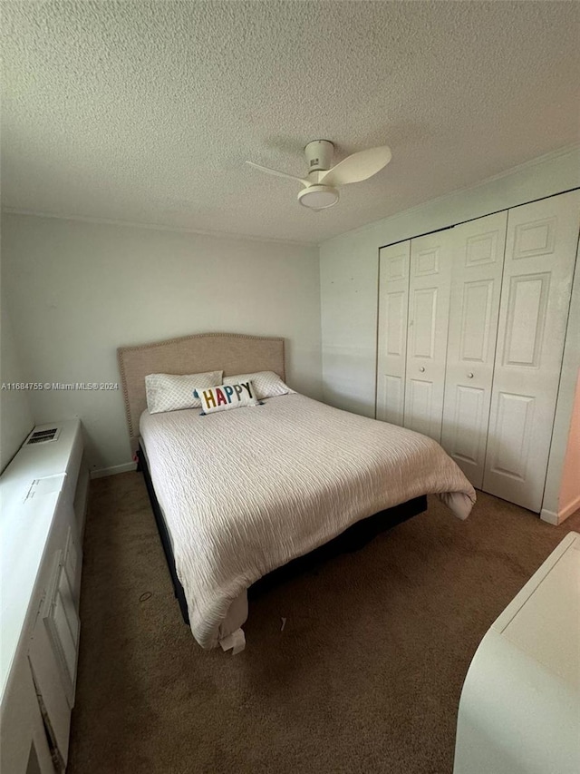 carpeted bedroom with a closet, ceiling fan, and a textured ceiling